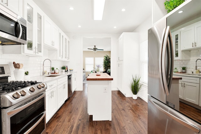 kitchen with a sink, stainless steel appliances, wooden counters, and dark wood finished floors