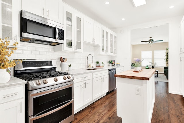 kitchen featuring wooden counters, appliances with stainless steel finishes, dark wood-style floors, white cabinets, and a sink