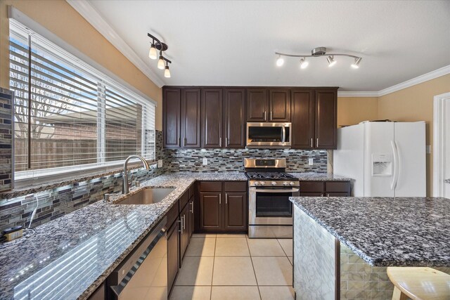 308 Highland Meadows Dr, Wylie, TX 75098 - kitchen featuring stainless steel appliances, a sink, light tile patterned floors, dark brown cabinetry, and decorative backsplash