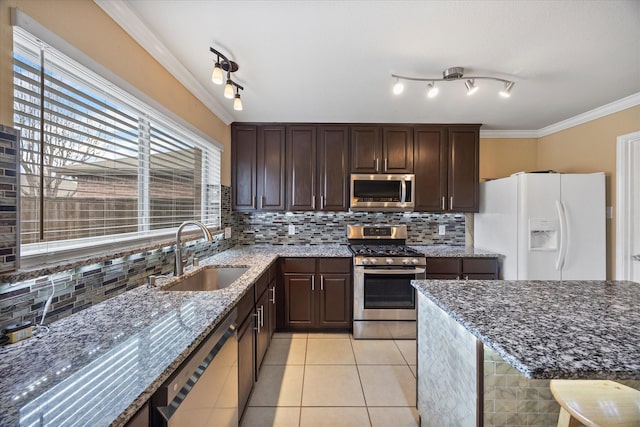 kitchen with backsplash, ornamental molding, light tile patterned floors, stainless steel appliances, and a sink