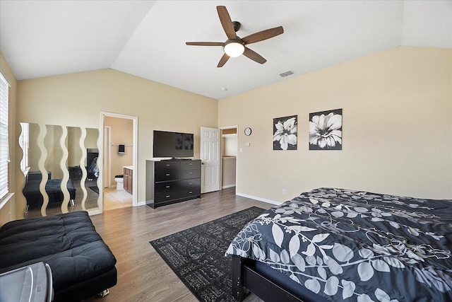 bedroom with vaulted ceiling, wood finished floors, visible vents, and baseboards