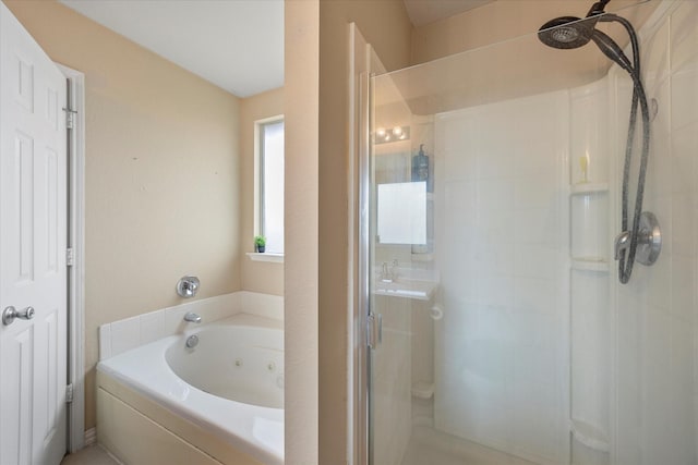 bathroom featuring a sink, a tub with jets, and a stall shower