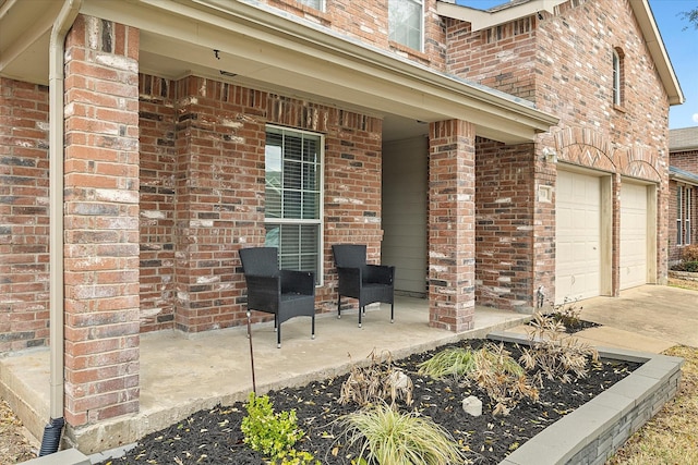 view of patio featuring a garage, a porch, and driveway