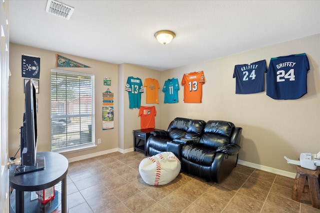 living room featuring baseboards and visible vents