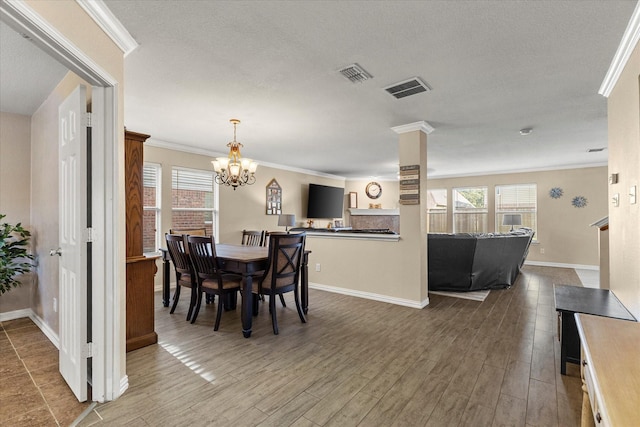 308 Highland Meadows Dr, Wylie, TX 75098 - dining room with healthy amount of natural light, a chandelier, baseboards, crown molding, and wood finished floors