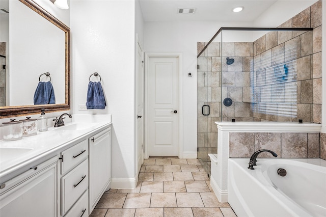 bathroom featuring visible vents, double vanity, a stall shower, a sink, and a garden tub