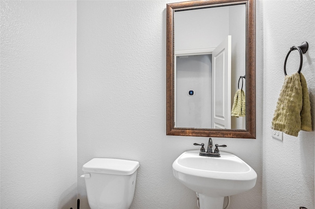 half bathroom with toilet and a sink