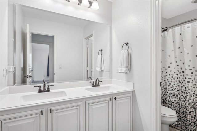 full bathroom with a sink, a shower with curtain, toilet, and double vanity