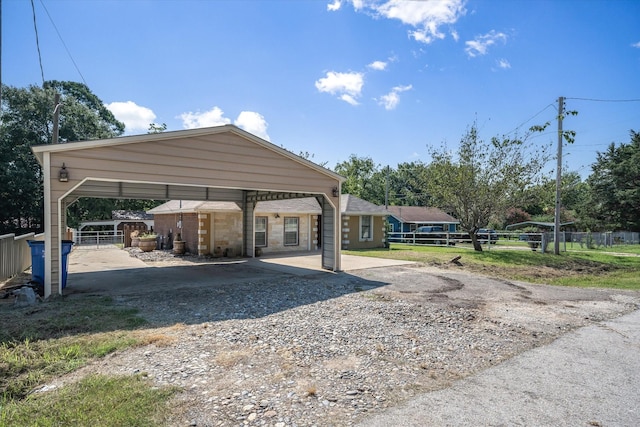 view of home's community with a detached carport, gravel driveway, and fence