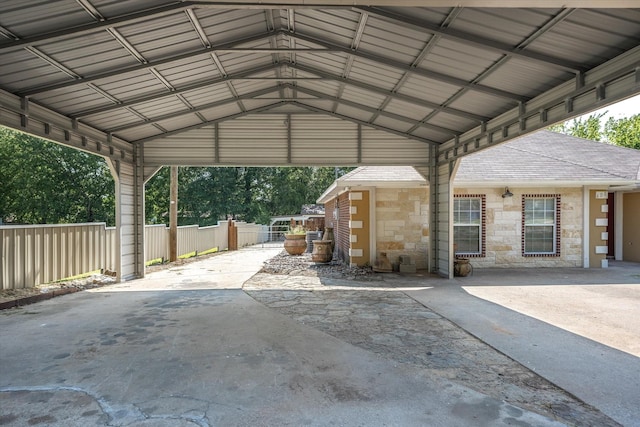 view of parking / parking lot featuring a carport and fence