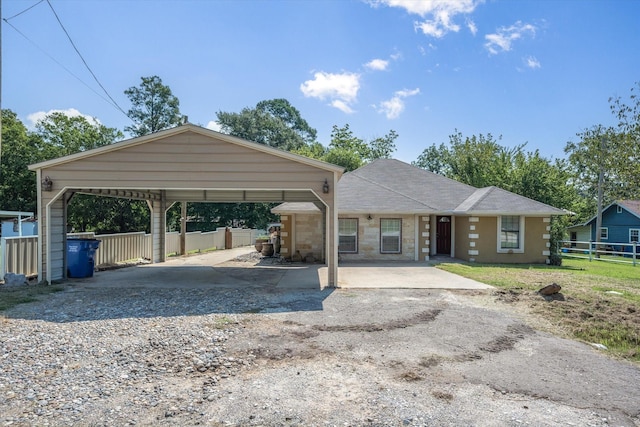 ranch-style house with a carport, fence, and driveway