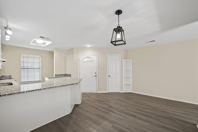 kitchen featuring visible vents, light stone countertops, baseboards, and dark wood-style floors