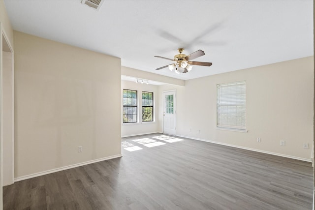 unfurnished room featuring visible vents, baseboards, a ceiling fan, and wood finished floors