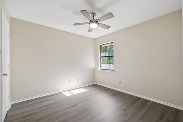 spare room featuring baseboards, wood finished floors, and a ceiling fan