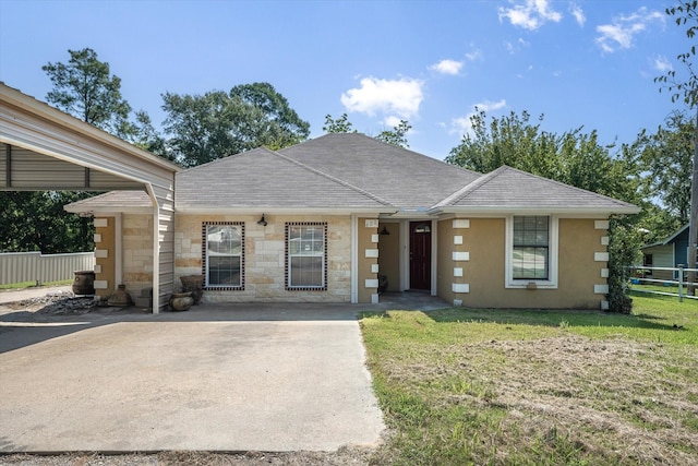 view of front of home with a shingled roof, a front lawn, fence, and stucco siding