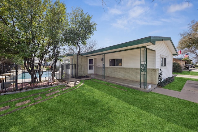 ranch-style house with a front lawn, fence, brick siding, and a patio area