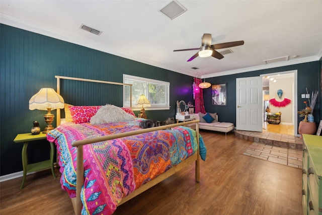 bedroom featuring visible vents, a ceiling fan, wood finished floors, and crown molding