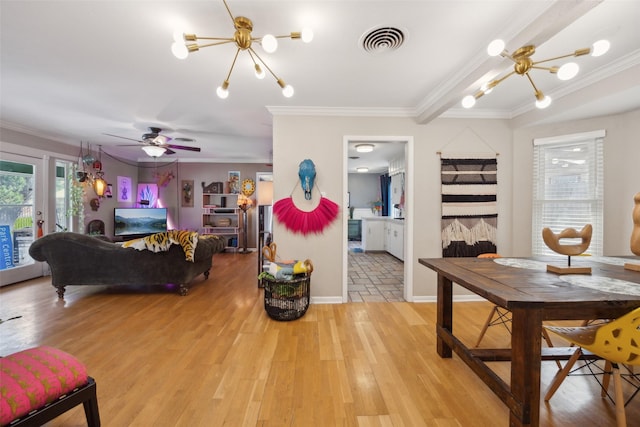 dining space featuring crown molding, light wood-style flooring, ceiling fan with notable chandelier, and visible vents