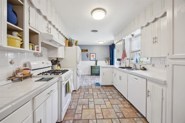 kitchen with white appliances, tile countertops, visible vents, and under cabinet range hood