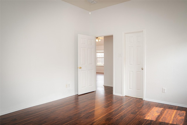 empty room with dark wood-style floors and baseboards