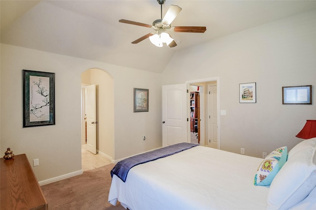 bedroom featuring baseboards, lofted ceiling, arched walkways, ceiling fan, and light carpet