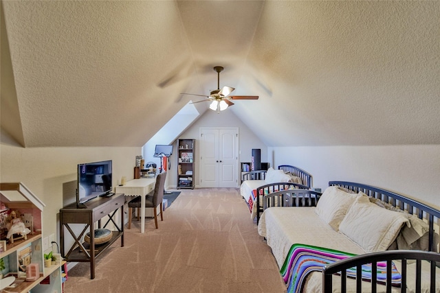 carpeted bedroom featuring a closet, lofted ceiling, a textured ceiling, and a ceiling fan