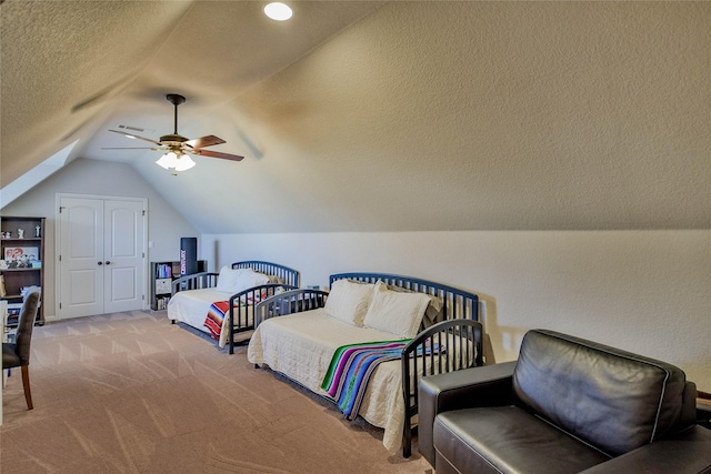 carpeted bedroom featuring visible vents, a textured ceiling, a closet, ceiling fan, and vaulted ceiling