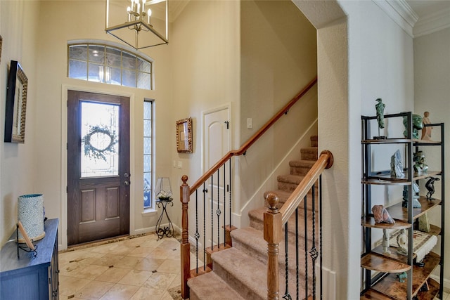 entryway with stairway, a high ceiling, crown molding, light tile patterned floors, and baseboards