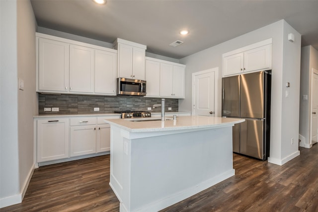 kitchen with white cabinetry, dark wood-style floors, backsplash, and stainless steel appliances