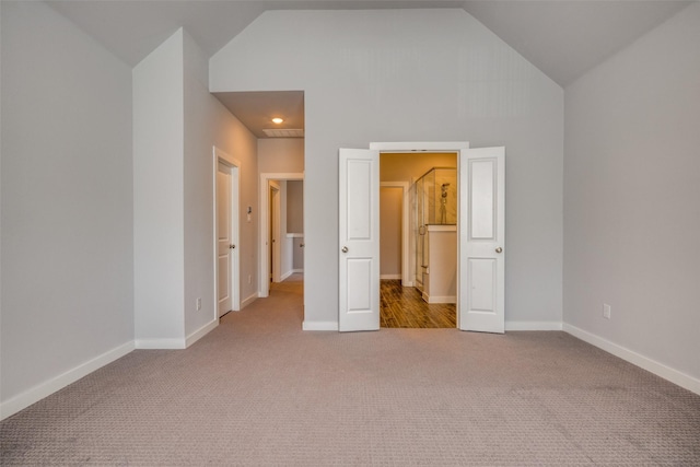 unfurnished bedroom with baseboards, carpet, and high vaulted ceiling