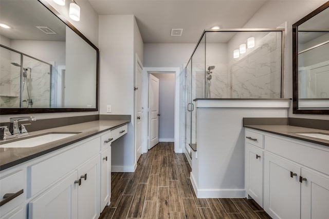 full bathroom with visible vents, a shower stall, wood finish floors, and a sink