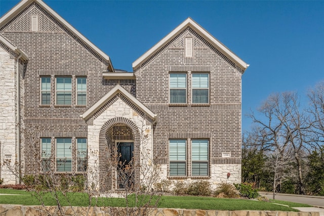 view of front of home with brick siding and stone siding