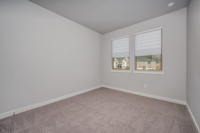 carpeted empty room with baseboards