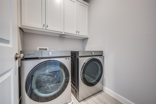 laundry room with light wood-style flooring, cabinet space, independent washer and dryer, and baseboards