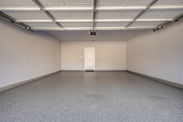 garage featuring a garage door opener and baseboards