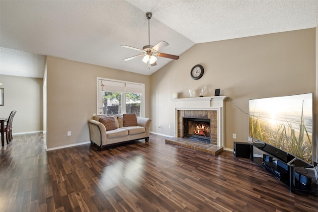 living area featuring a ceiling fan, wood finished floors, baseboards, a brick fireplace, and vaulted ceiling