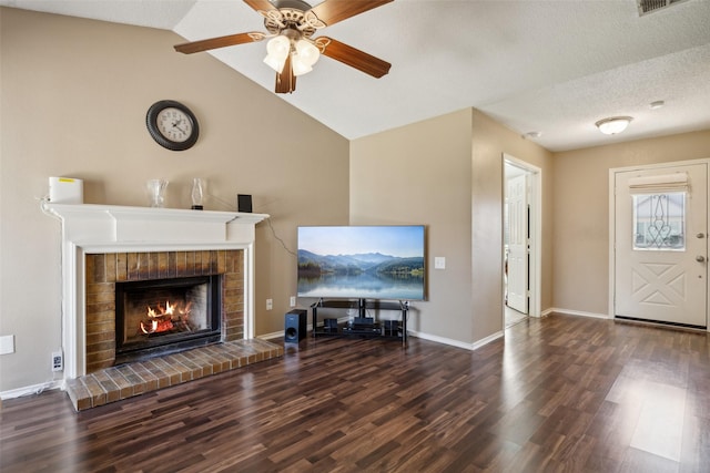 unfurnished living room featuring vaulted ceiling, a brick fireplace, wood finished floors, and ceiling fan