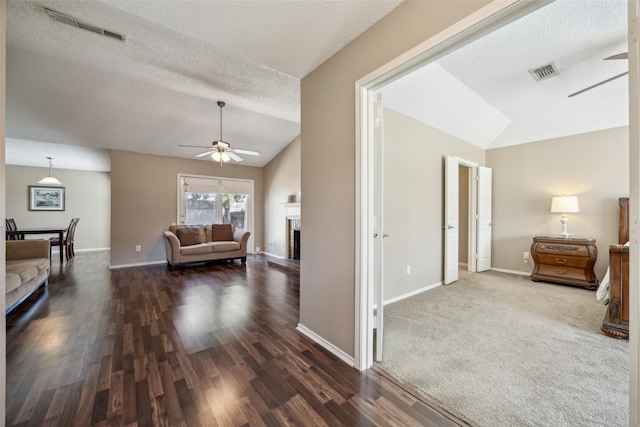 interior space with visible vents, a textured ceiling, baseboards, and vaulted ceiling