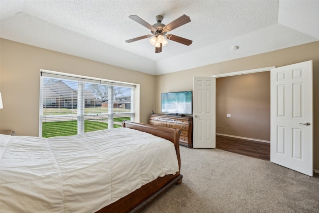 bedroom featuring a textured ceiling, light colored carpet, ceiling fan, and vaulted ceiling