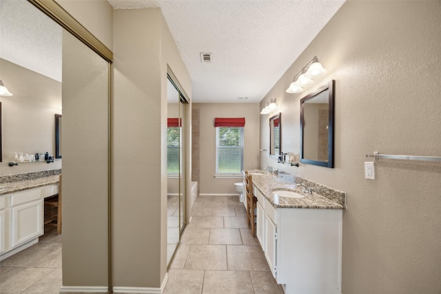 full bath with vanity, visible vents, tile patterned flooring, a textured ceiling, and toilet