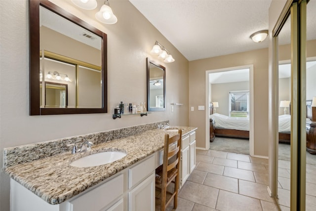 full bath with visible vents, ensuite bath, double vanity, a sink, and tile patterned floors