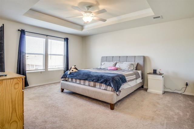 bedroom featuring visible vents, a raised ceiling, light colored carpet, and ornamental molding