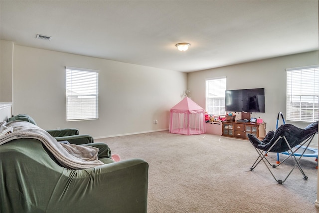 carpeted living room with visible vents, plenty of natural light, and baseboards