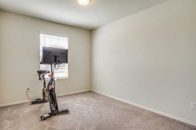 exercise room with baseboards and carpet flooring