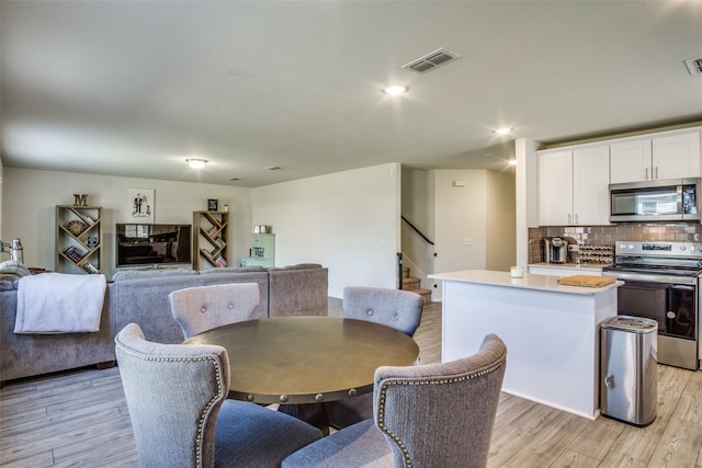 dining space with stairs, recessed lighting, visible vents, and light wood finished floors