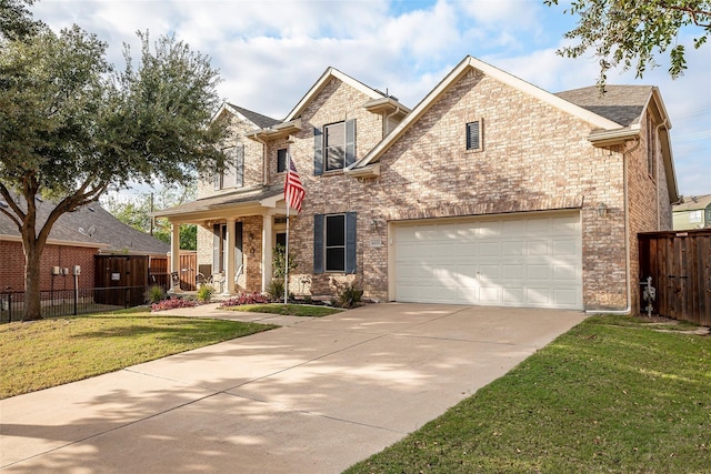 traditional-style home with brick siding, driveway, a front lawn, and fence