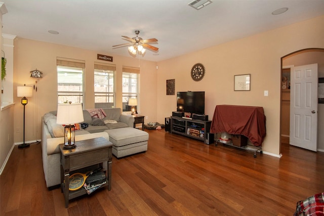 living room featuring visible vents, wood finished floors, arched walkways, and ceiling fan