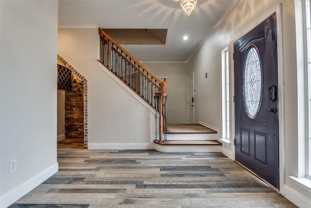 entryway featuring stairway, wood finished floors, baseboards, recessed lighting, and crown molding