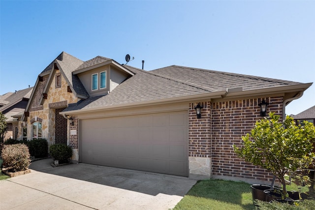 view of front of house featuring brick siding, stone siding, an attached garage, and driveway