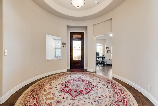 foyer featuring dark wood-type flooring and baseboards